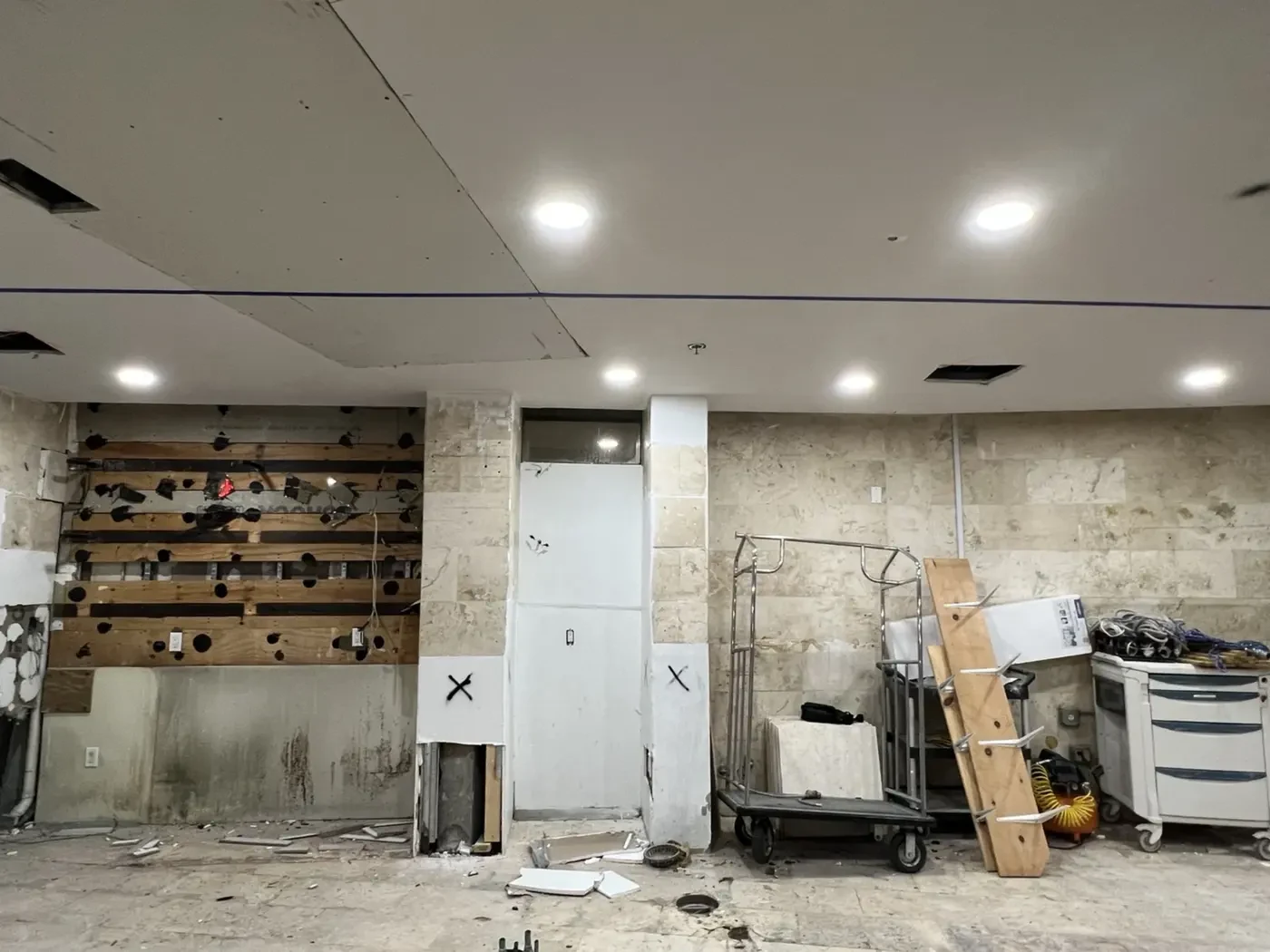 Before renovation photo at Brisa Casa on Ocean Drive, South Beach Miami, showing stripped wall surfaces, temporary lighting, and construction staging prior to IV Atelier interior design buildout.