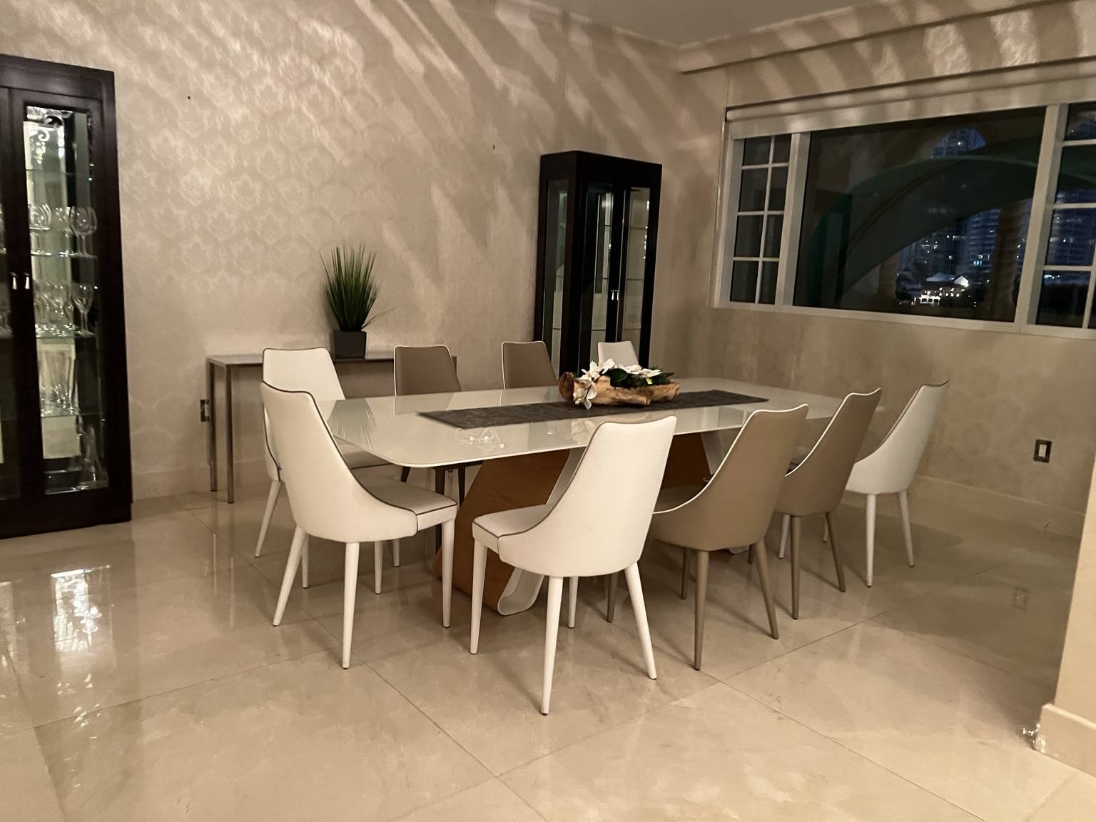 Before renovation: original dining area with marble floor and mixed seating at Fisher Island residence prior to IV Atelier floor plan redesign