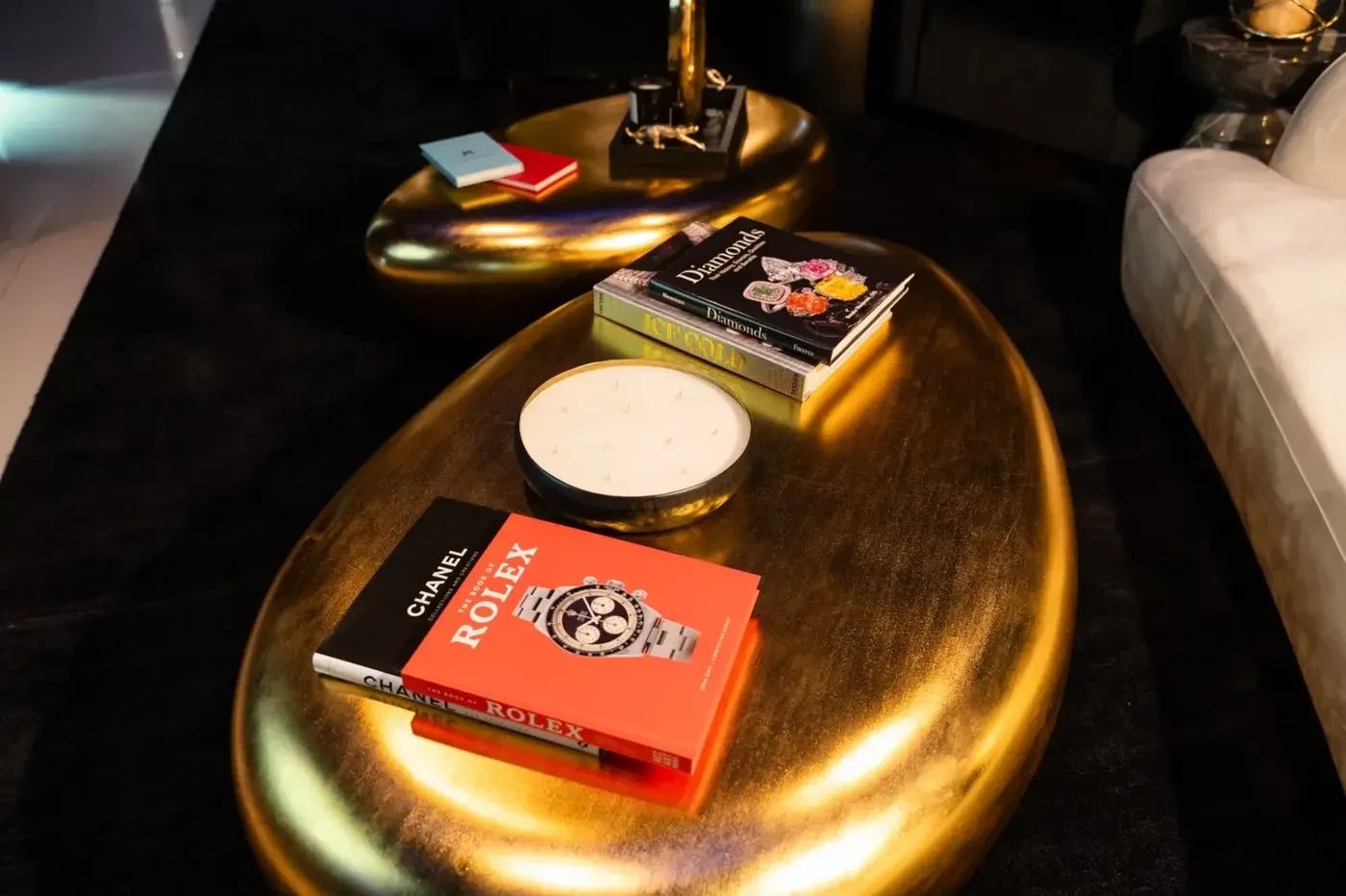 Luxzen coffee table — Rolex, Chanel and Diamonds books on sculpted gold surface.