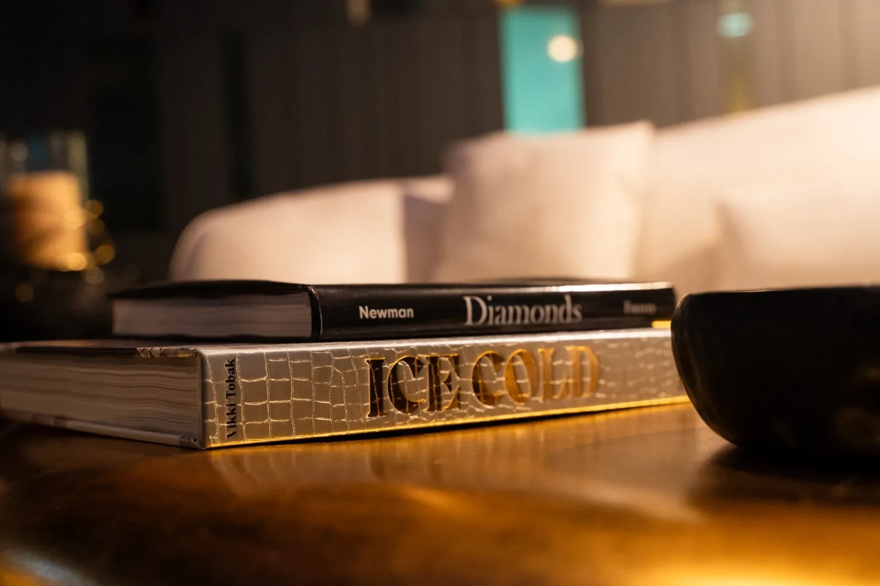 Luxzen coffee table — Ice Cold and Diamonds books on gold sculptural surface.