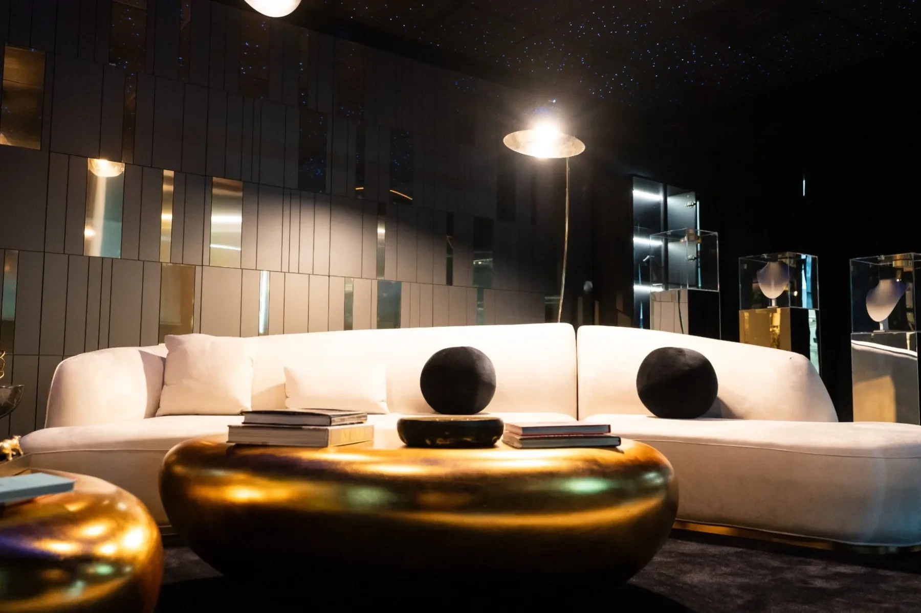 Luxzen lounge — white curved sofa with spherical pendants overhead.