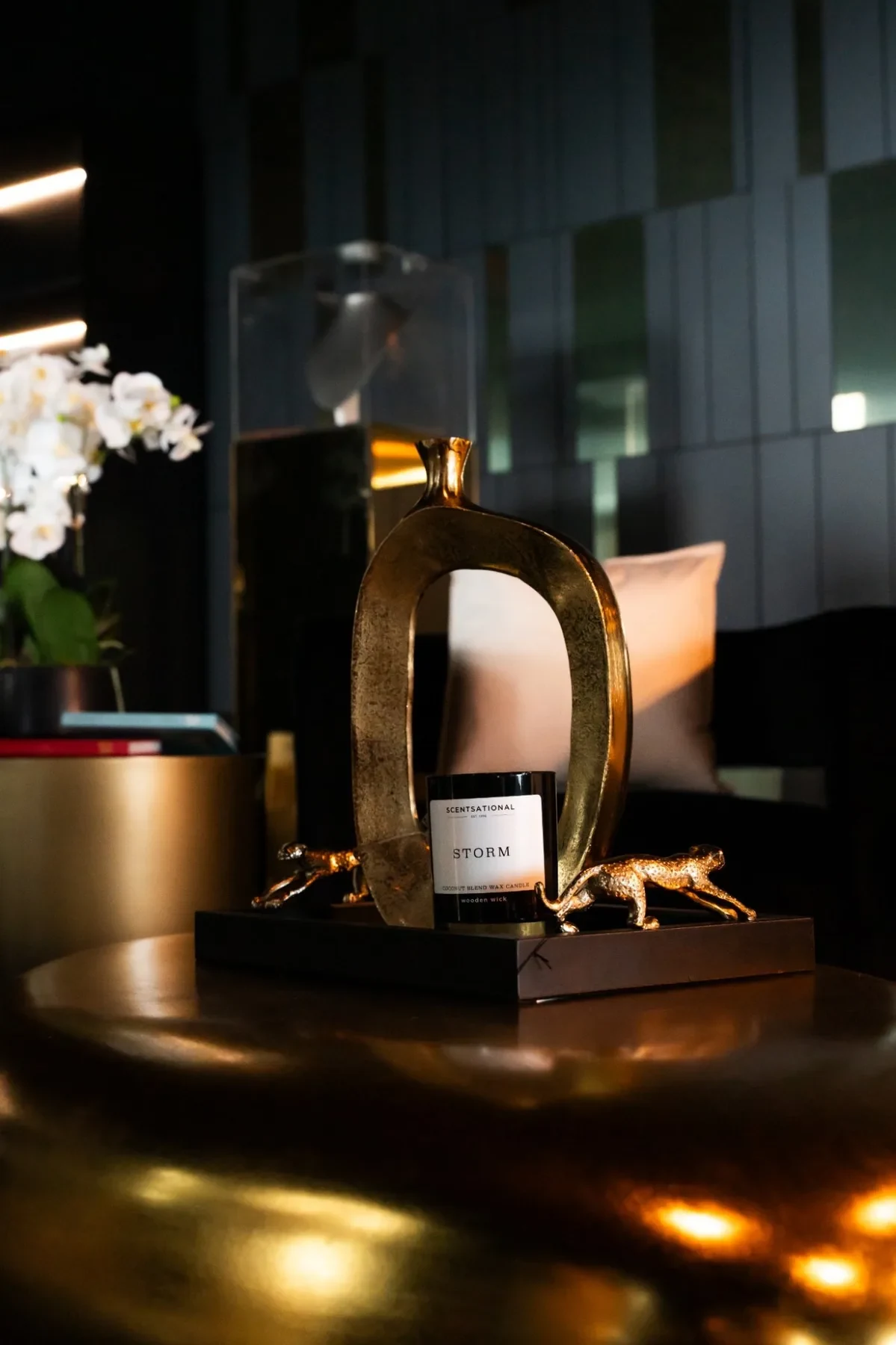 Luxzen styling — Storm candle on gold tray with cheetah figurines.