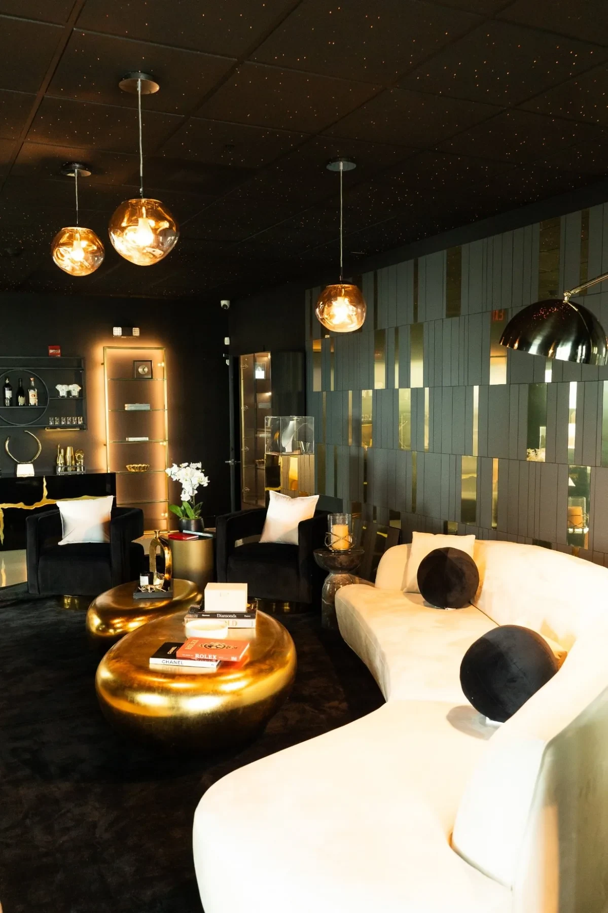 Luxzen lounge — curved white sofa, gold coffee tables and starry black ceiling.