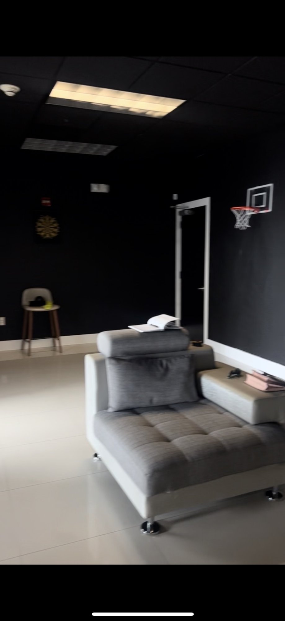 Before — existing space with dart board and basketball hoop.