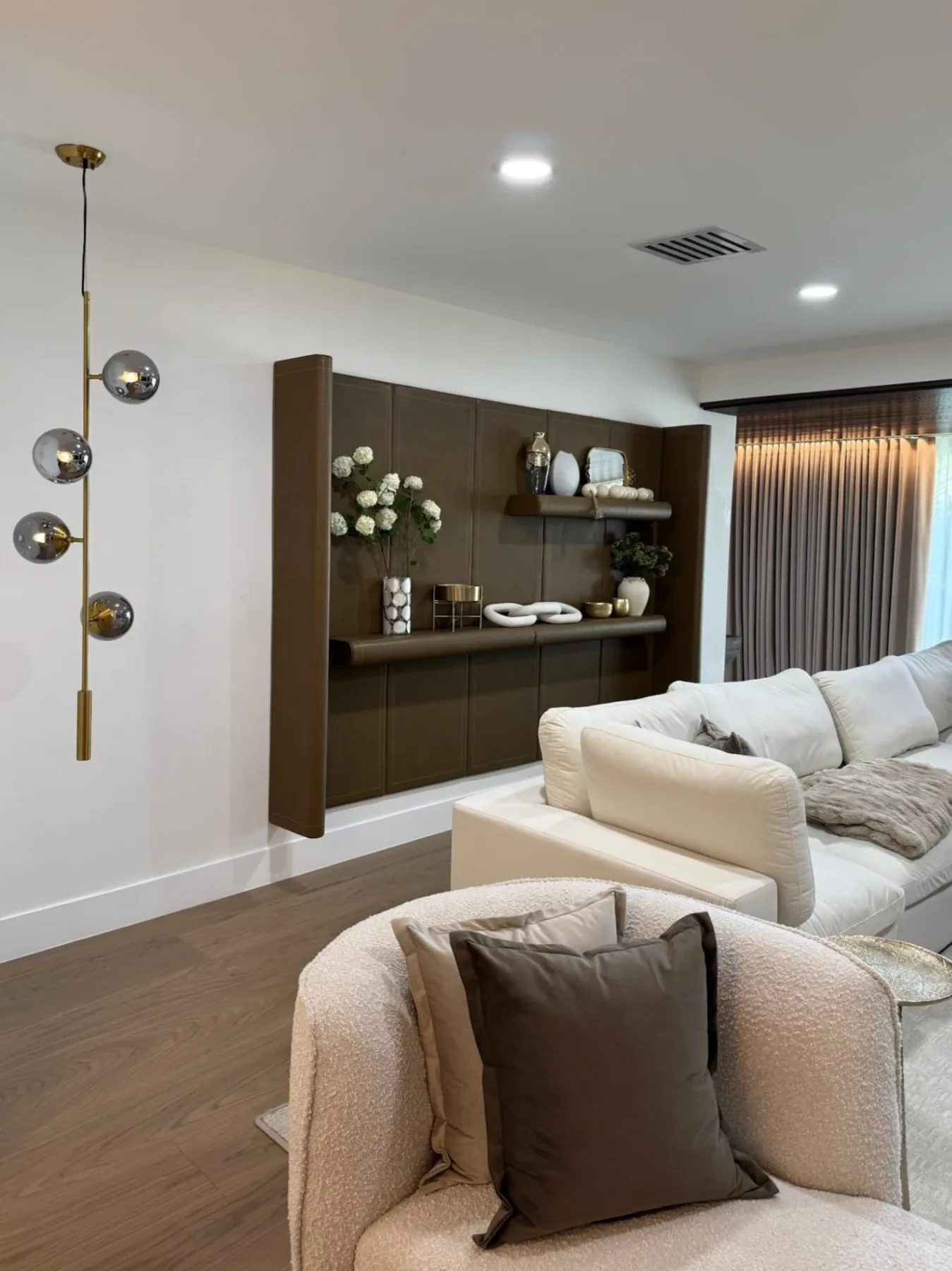 San Souci Residence — living room feature wall with globe pendant and boucle armchair.