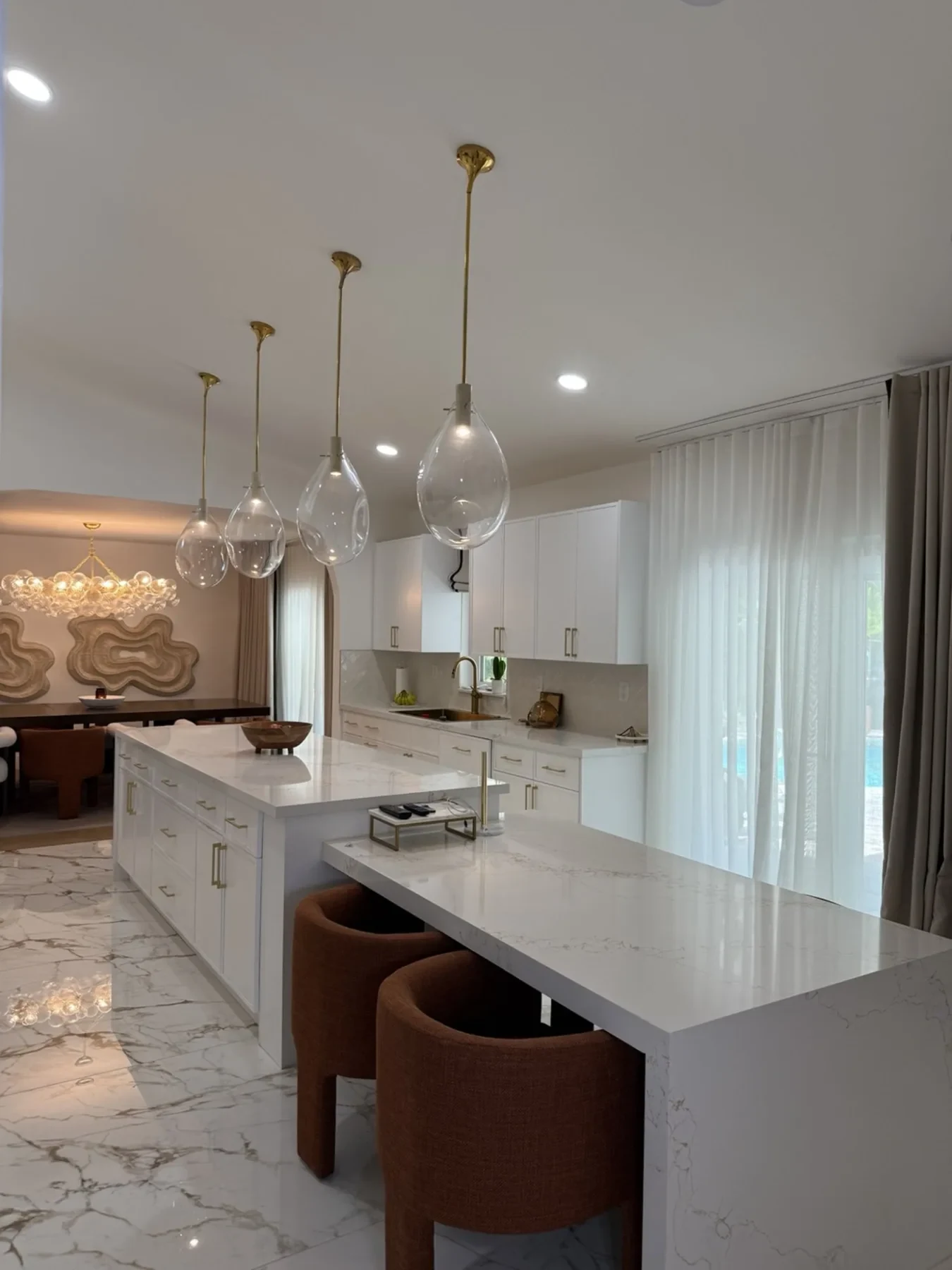 San Souci Residence — kitchen island with brass hardware and terracotta bar stools.