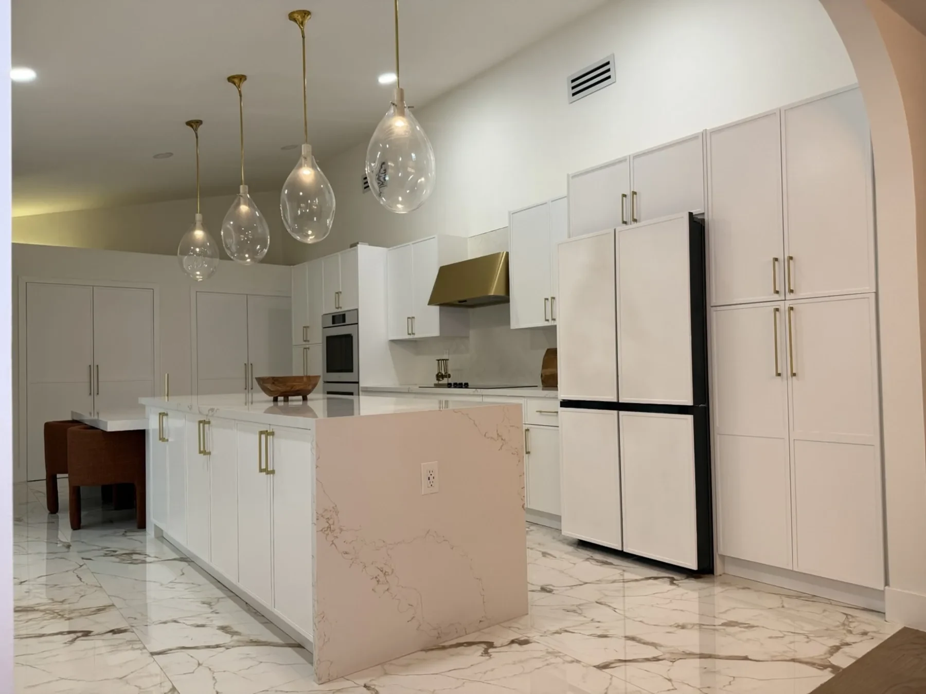San Souci Residence — kitchen island viewed through arched doorway.